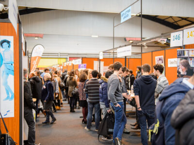 STRASBOURG, FRANCE - FEB 4, 2016: Children and teens of all ages attending annual Education Fair to choose career path and receive vocational counseling - rows of college stands